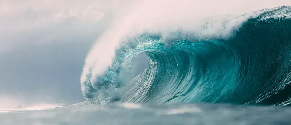 A turquoise wave cresting in the open ocean
