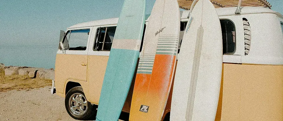 A vintage surf van parked beside the coast