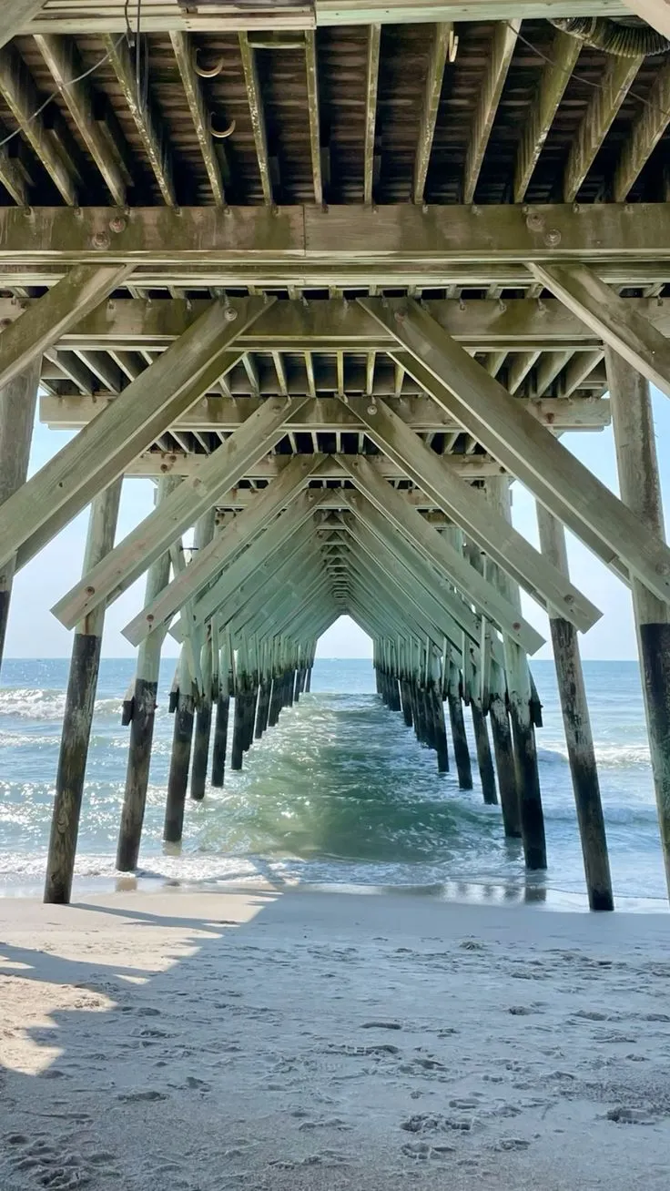 A wooden pier framing the ocean and shoreline